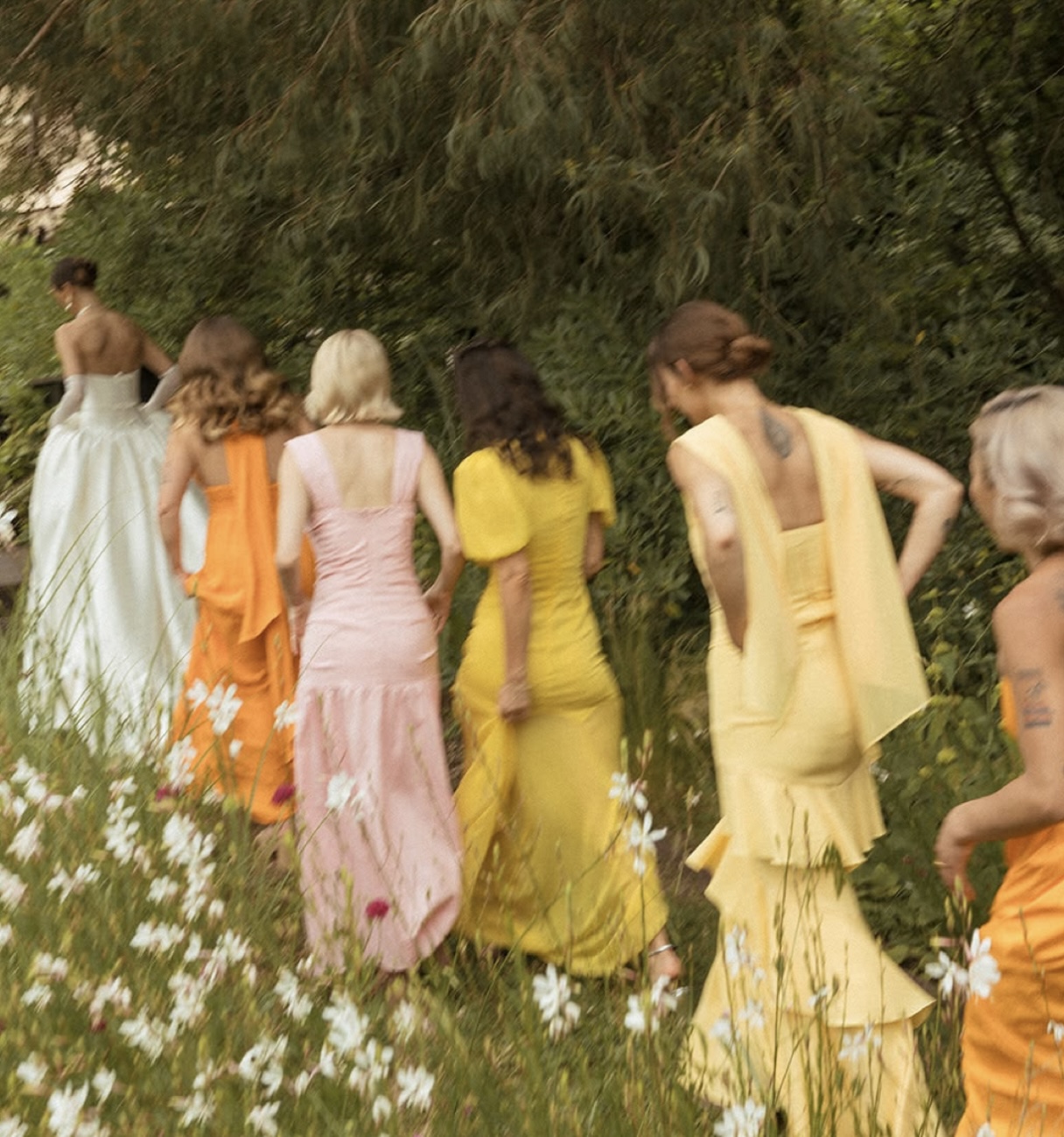 Guests walking through a garden in colourful dresses