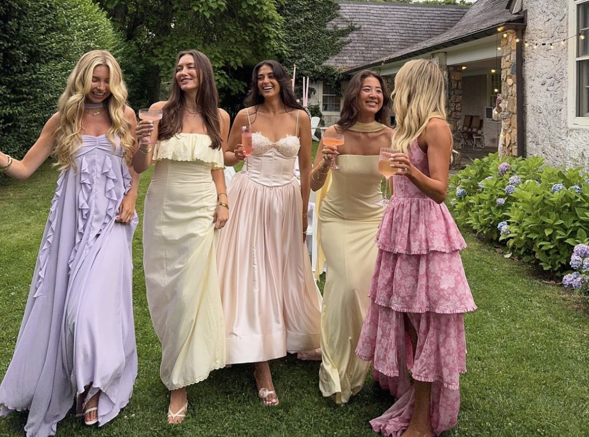 Friends in pastel dresses at a garden celebration