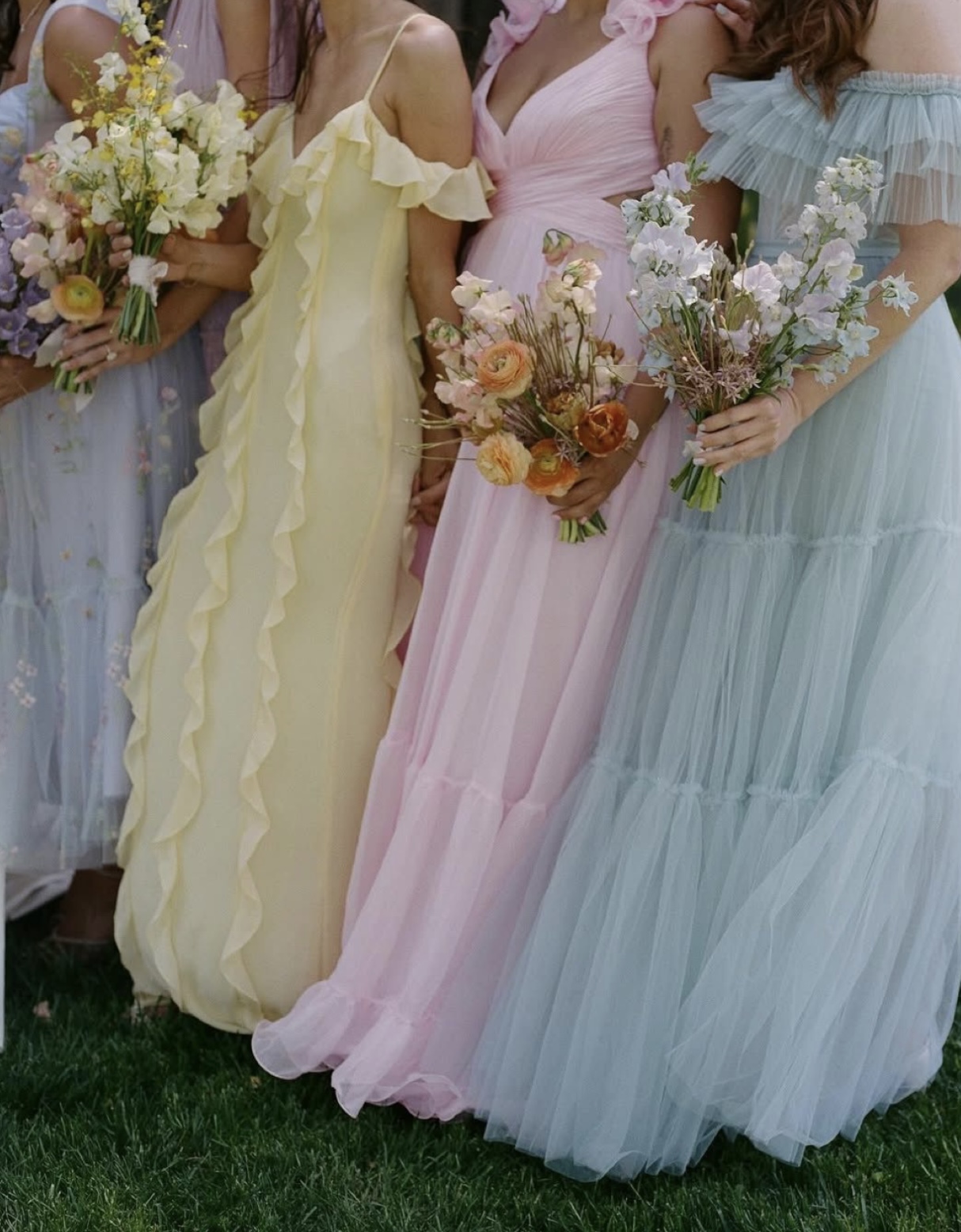 Guests in pastel dresses with bouquets